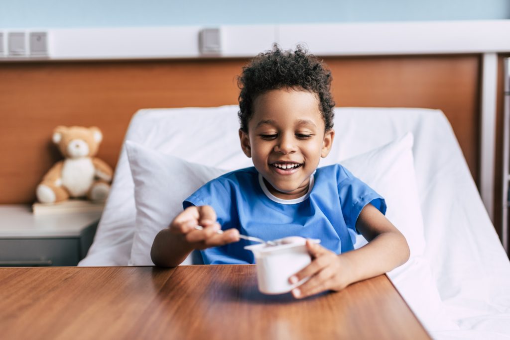 child eating yogurt and smiling