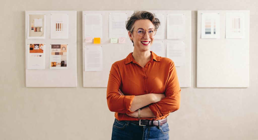 woman smiling in front of four paper posters